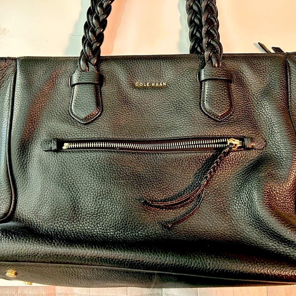 Black Cole Haan leather purse with braided handle and navy blue interior